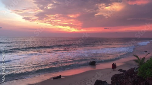 Amazing sunset over tropical beach Varkala, India. Kerala beach and dog, multiple colors colorful sunset sky and motion blurred Laccadive Sea at Papanasam beach India. Summer orange sunset a rocky photo