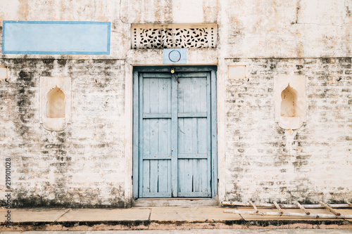 Vintage style brick wall and sky blue wooden door  Old Indian house