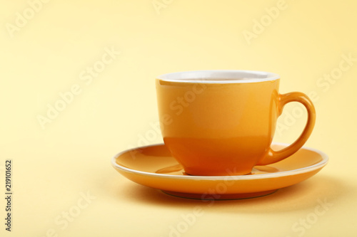 Yellow cup of tea or coffee on saucer
