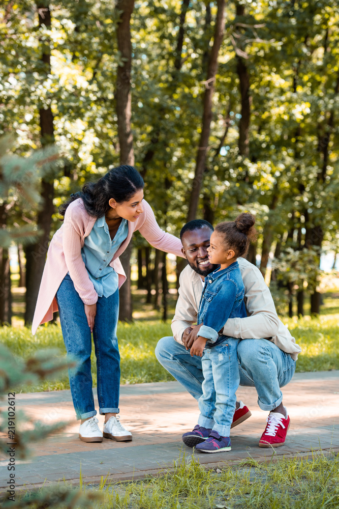 Fototapeta premium african american parents looking at daughter on path in park