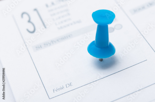 closeup of blue pin in agenda on 31 December date