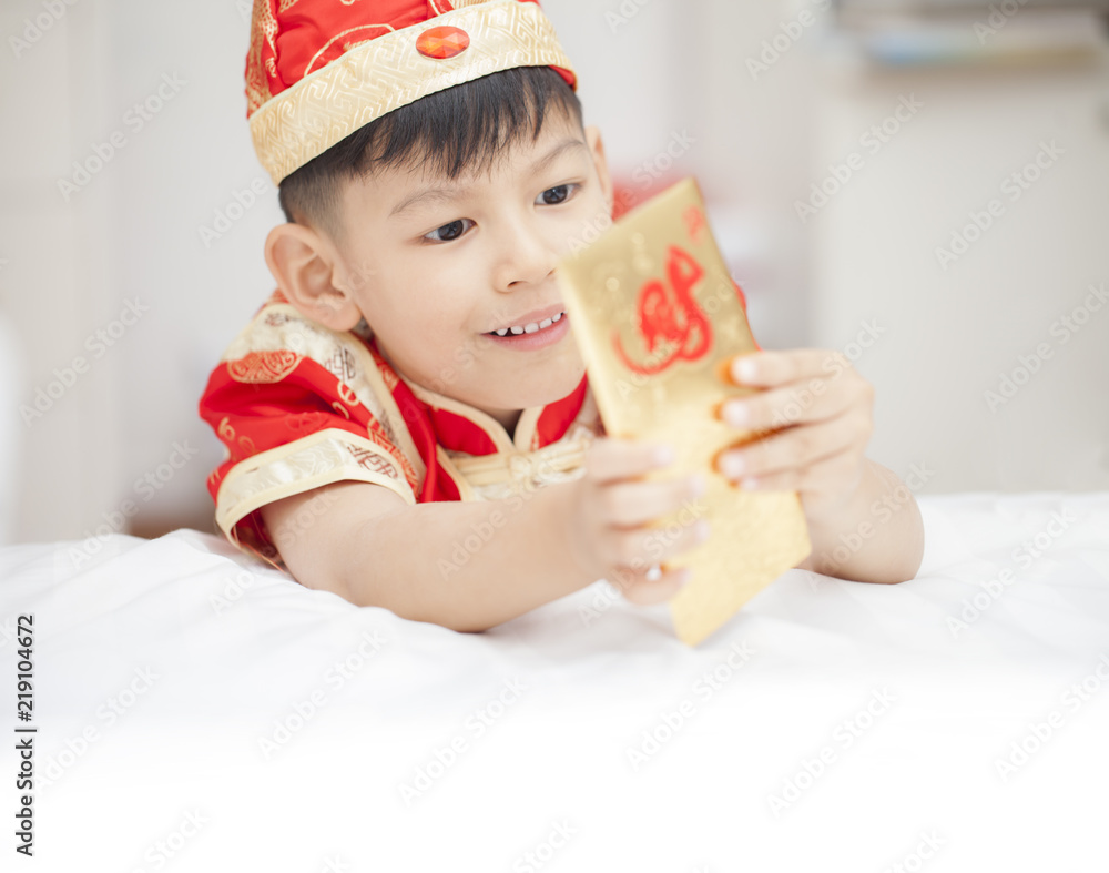 Southeast Asian adorable boy in cheongsam hands holding red packets / ang pow. Southeast Asian adorable boy in cheongsam hands holding red packets / ang pow.