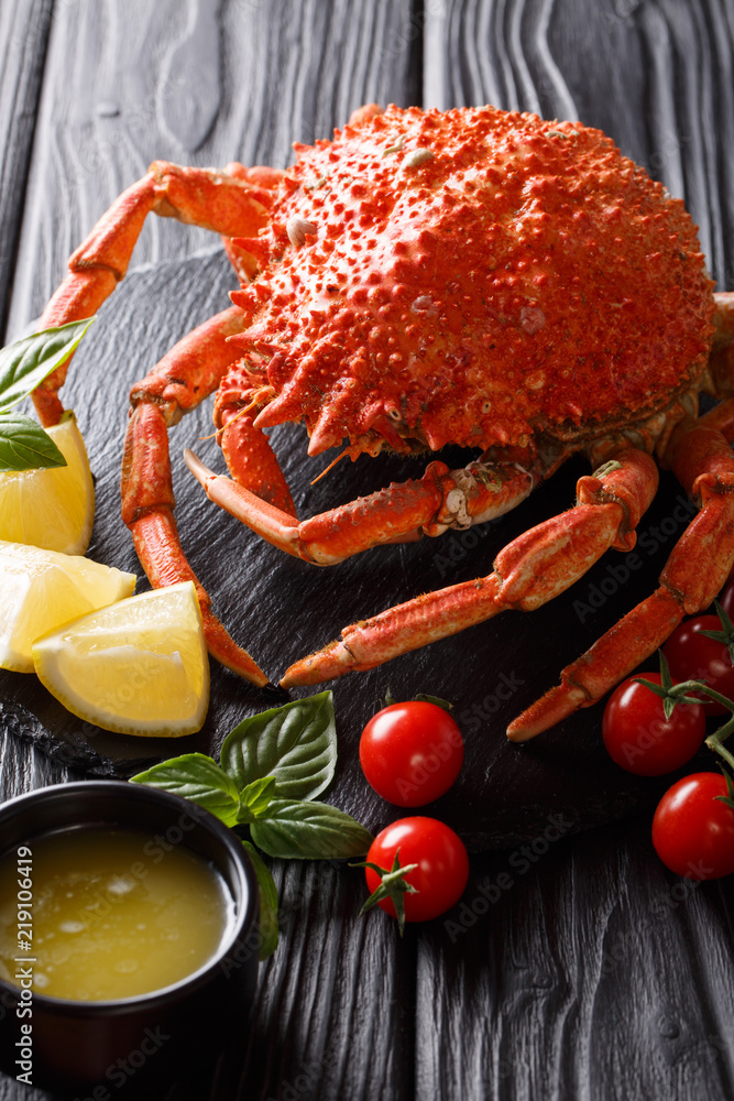Expensive food: cooked whole crab spider with lemon and melted butter close-up. vertical Expensive food: cooked whole crab spider with lemon and melted butter close-up. vertical