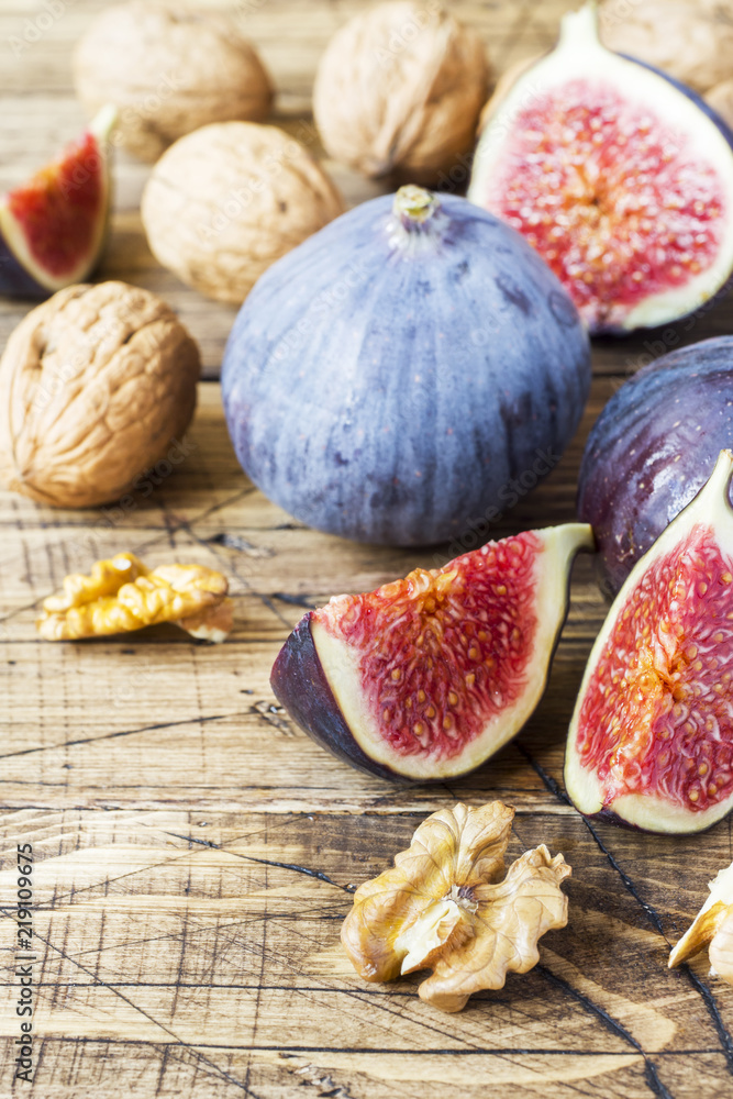 Fresh figs whole and cut with walnut kernels on a wooden old background. copy space Fresh figs whole and cut with walnut kernels on a wooden old background. copy space