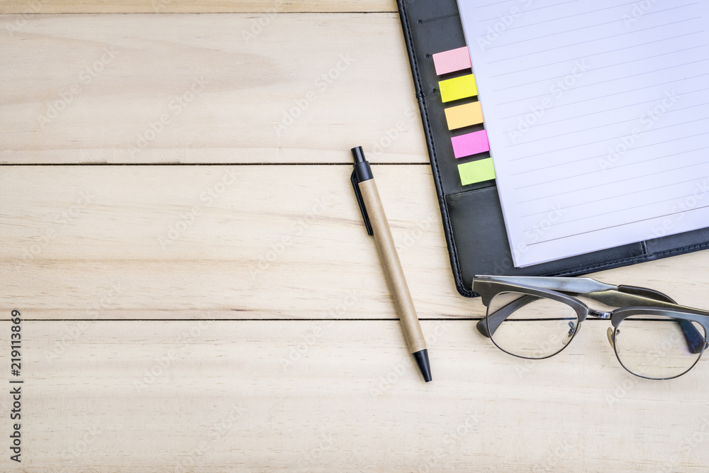 Relaxing after working, Modern office desk with pen eyeglass and blank notebook on wooden, Blank space for insert wording Relaxing after working, Modern office desk with pen eyeglass and blank notebook on wooden, Blank space for insert wording