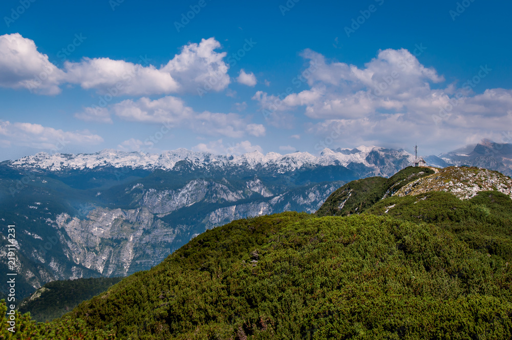 Triglav National park mountains with a small house on top of the green hills