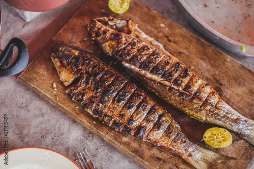 Authentic grilled  fish in a cutting board. horizontal view from above