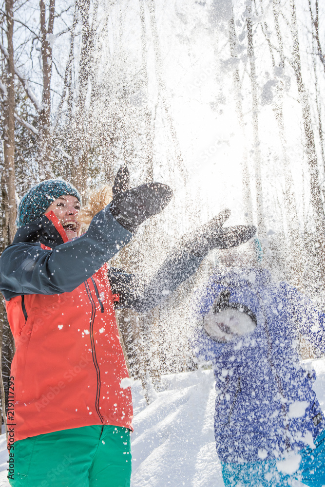 Pair of female friends snowshoeing in forest.