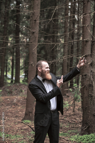 confident businessman in a business suit taking a selfie in a forest.