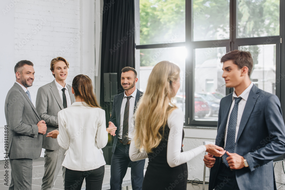 young professional businesspeople standing and talking in hub young professional businesspeople standing and talking in hub