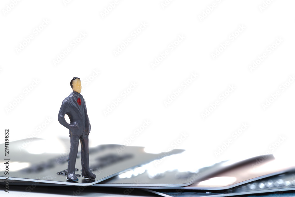 Figure miniature businessman or small people standing with stack of credit card on white background for money and shopping concept. Figure miniature businessman or small people standing with stack of credit card on white background for money and shopping concept.