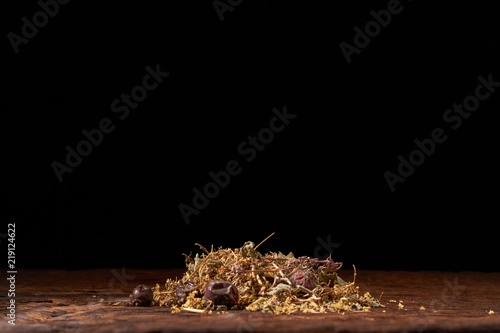 Herbal tea on wooden table on black background. Concept organic food