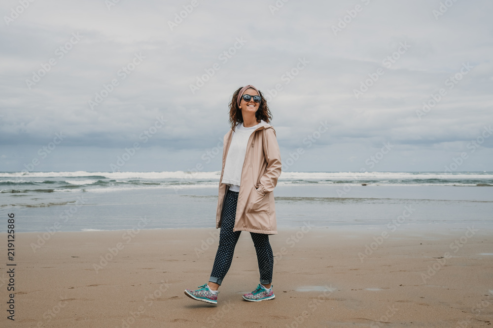 .Young and cheerful girl walking through a huge beach in northern Spain, in Asturias. On a cloudy summer day. Enjoying relaxed and at peace. Lifestyle. .Young and cheerful girl walking through a huge beach in northern Spain, in Asturias. On a cloudy summer day. Enjoying relaxed and at peace. Lifestyle.