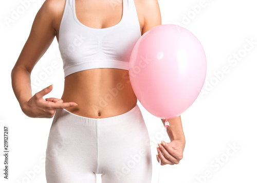 Photos Woman holding a balloon, feeling bloated concept