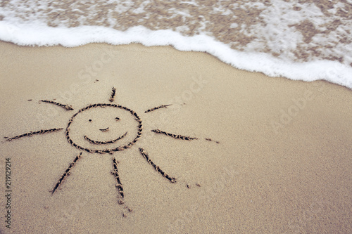 Sun drawing in the sand at the caribbean beach.