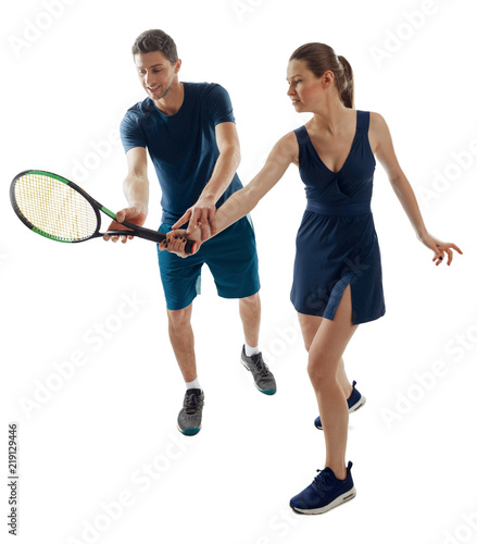 Young woman learns to play tennis with a male coach. Racket grip and other basic skills. Full-length portrait on white.