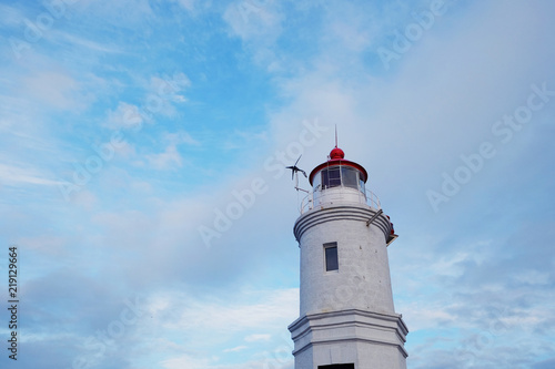 Lighthouse sea beacon against the background of the blue sky