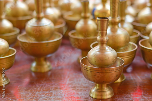 A golden brass pour ceremonial water jar used in traditional Buddhists after making merit and virtue. Pouring ceremonial water as a sign of dedication of merit to the departed.
