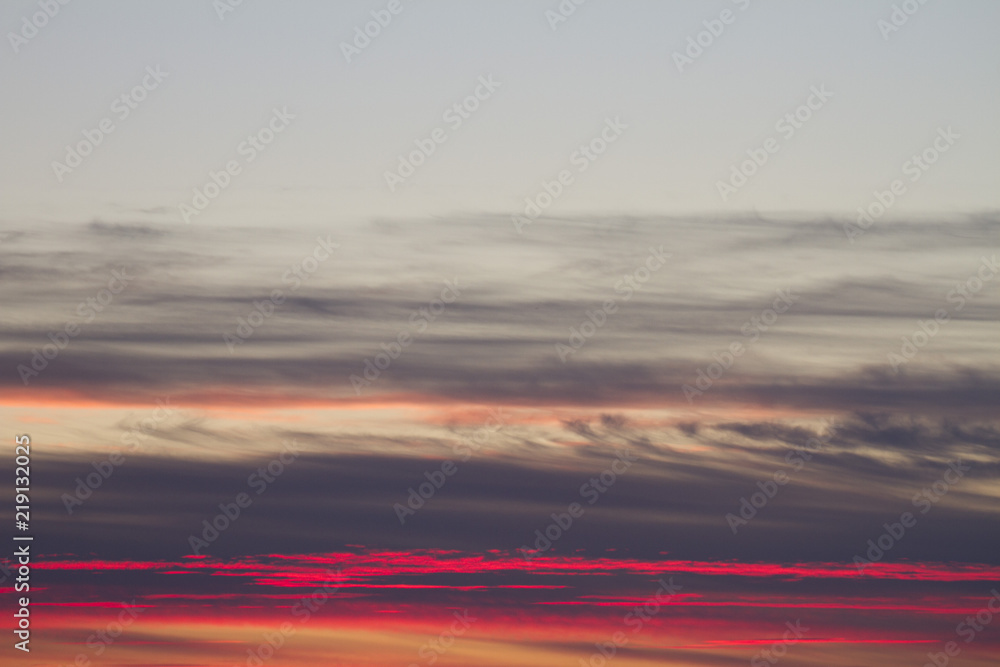 Sky clouds background. Cumulus pink red clouds in the sunset. Color clouds in the evening. Sky with a pastel colored background
