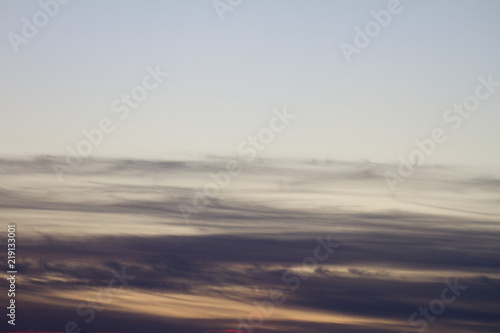 Sky clouds background. Cumulus clouds in the sunset. Color clouds in the evening. Sky with a gray pastel colored background