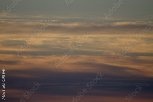 Sky clouds background. Cumulus clouds in the sunset. Color clouds in the evening. Sky with a gray pastel colored background