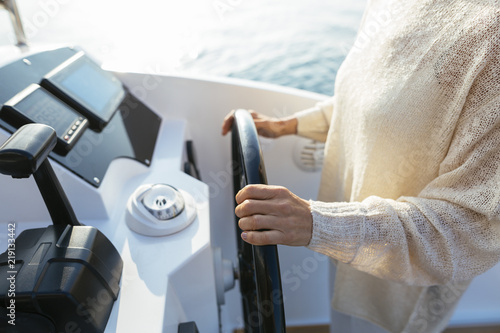Mature woman navigating catamaran on a sailing trip photo