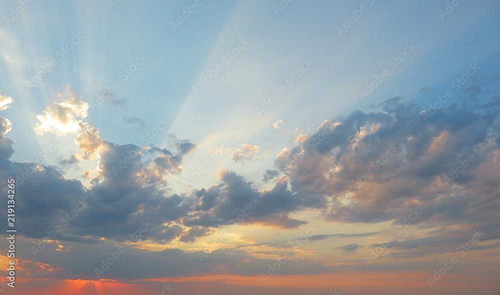 Beautiful colorful sunset background, the sun rays break through clouds Beautiful colorful sunset background, the sun rays break through clouds