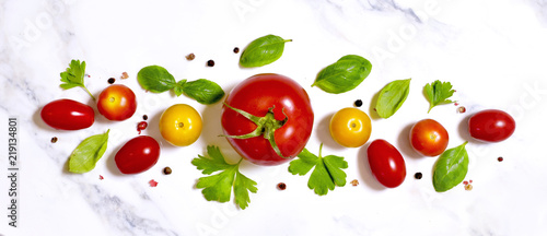 Delicious fresh tomatoes on a white marble stone background. Top view with copy space.