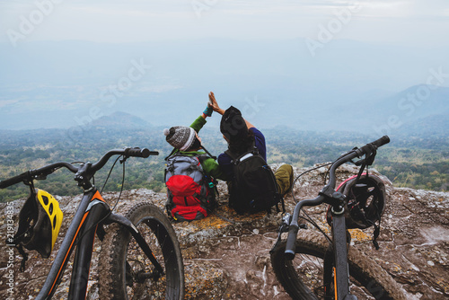  Asian lover woman and man Travel Nature. Travel relax ride a bike Wilderness in the wild. Sit on a rocky cliff. photo