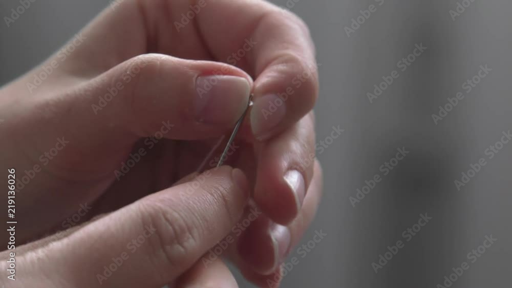The woman holding a needle and thread. Closeup, Macro. The woman holding a needle and thread. Closeup, Macro.
