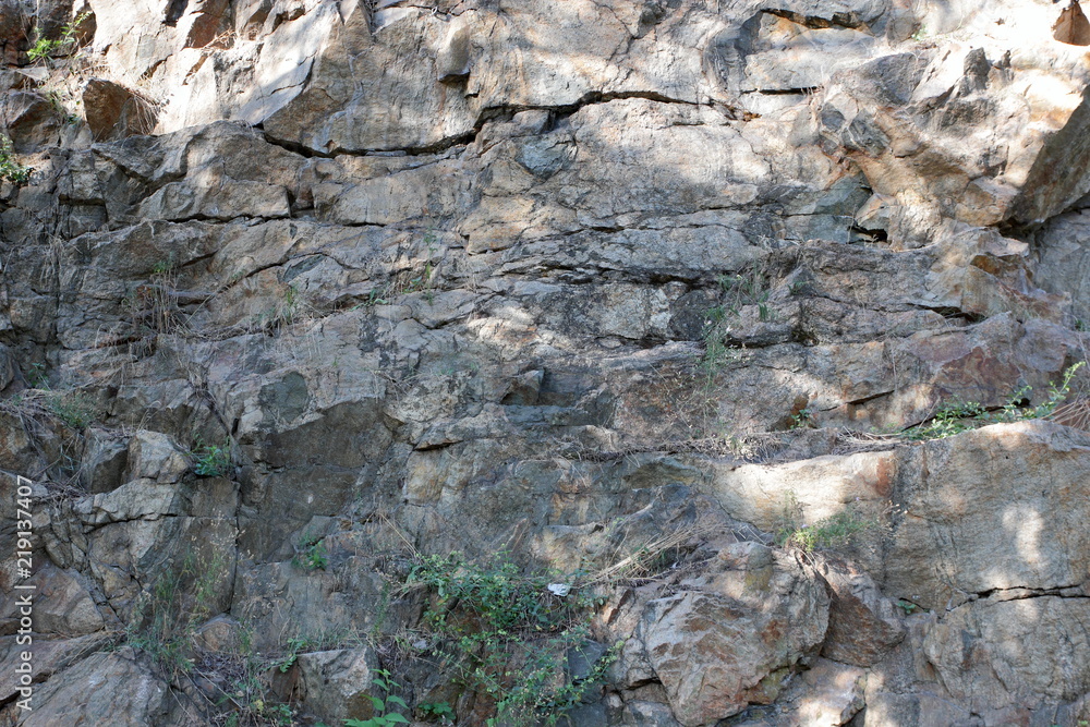 Granite rocks in the sun. Texture of granite stone. Background of natural material. Rocky rocks of ancient times Granite rocks in the sun. Texture of granite stone. Background of natural material. Rocky rocks of ancient times
