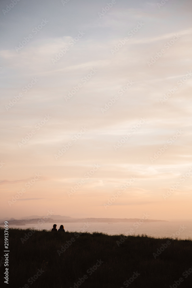 Couple watching sunset on seaside Couple watching sunset on seaside