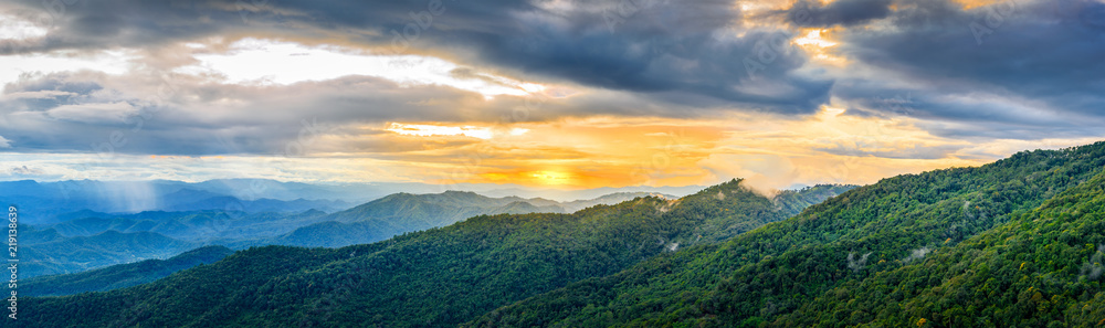 Dramatic sunset and sunrise sky and clouds over blue landscape mountains layers