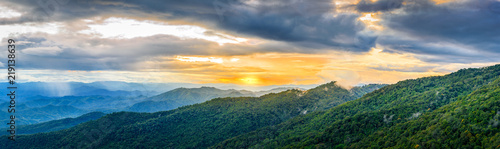 Dramatic sunset and sunrise sky and clouds over blue landscape mountains layers