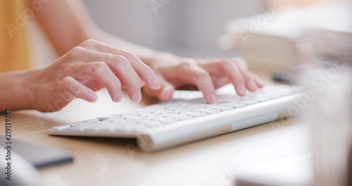 Woman typing on computer keyboard photo