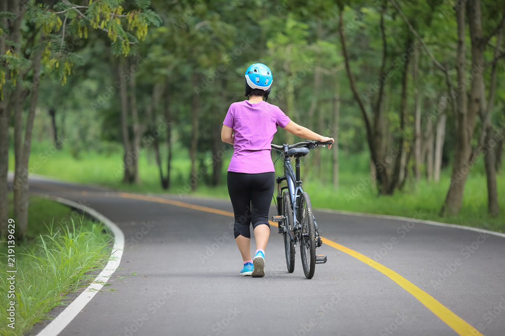 Obraz premium Middle aged relaxing exercise with bicycle in park