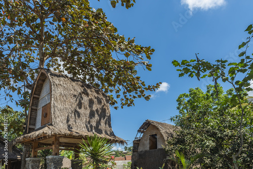 The traditional design of the exterior of SASAK houses in Lombok Island, Indonesia; the frame and roof are made of wood, bamboo and straw leaves of coconut trees photo