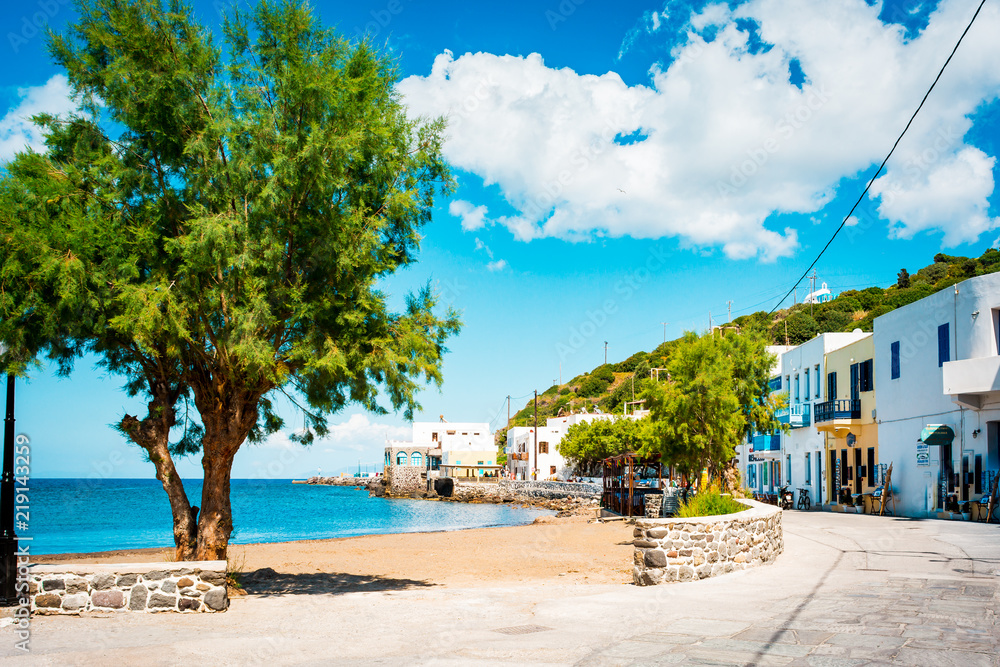 Greek village, coastal town with white houses and trees next to the beach, Mandraki on Nisyros Island, Greece