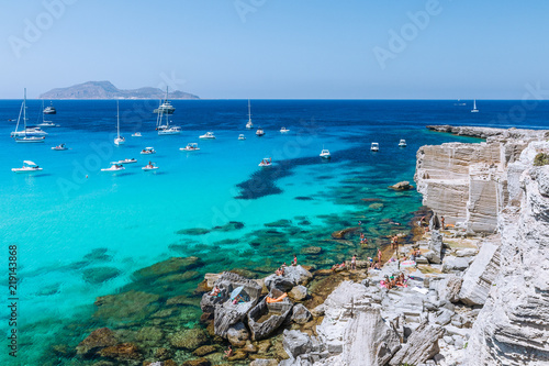 Beautifu panoramic view of rocky beach and blue lagoon with sailing boats. Favignana island photo