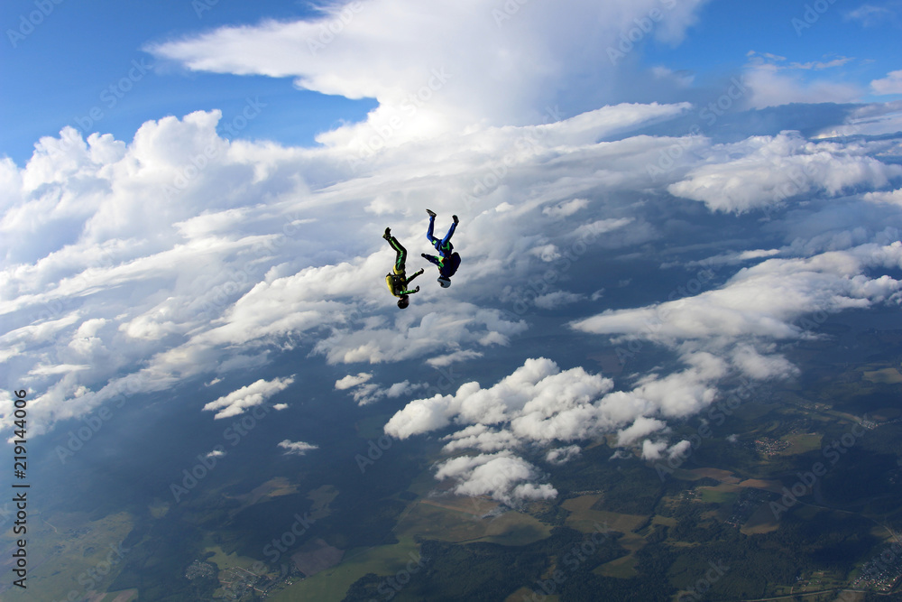 Two skydivers are falling in the amazing sky.