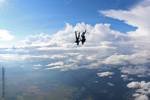 Two skydivers are falling in the amazing sky.