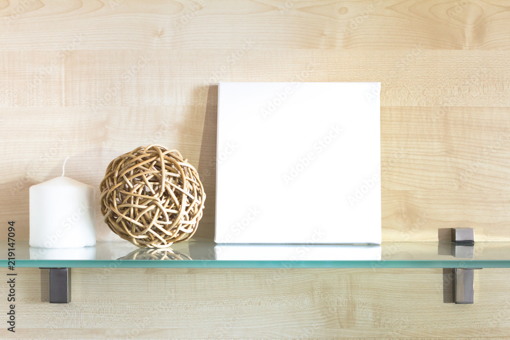 White canvas on a stretcher in the interior. Mockup poster for design. Glass shelf and wooden board on background. White canvas on a stretcher in the interior. Mockup poster for design. Glass shelf and wooden board on background.