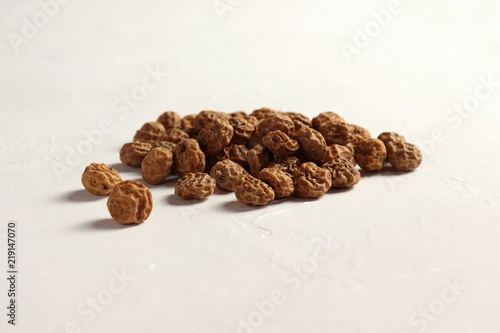 Isolated Tigernuts / earth almonds / nutsedges on slightly structured white surface photo