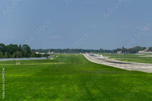 plane goes on take-off on the runway, the green grass, the blue sky