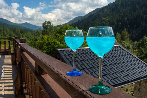 glasses with blue champagne against the background of the mountains