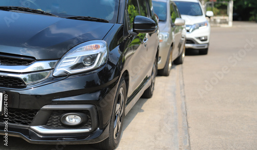Closeup of front side view of black car parking beside the street. © Amphon