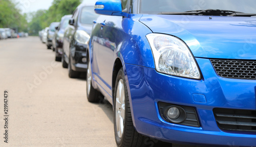 Closeup of front side view of blue car parking beside the street. © Amphon