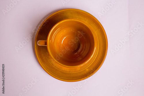 empty brown clay tea cup on lilac background. top view