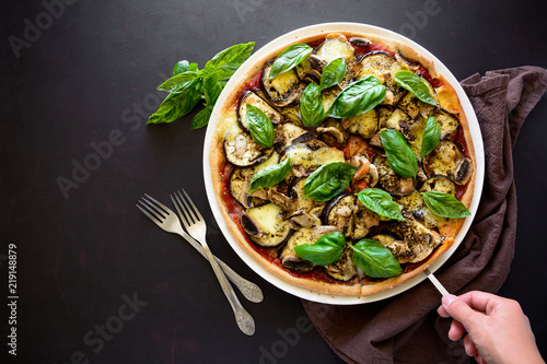 Vegetarian pizza with eggplant, tomato, mushrooms and basil on dark wooden background. Top view. Copy space