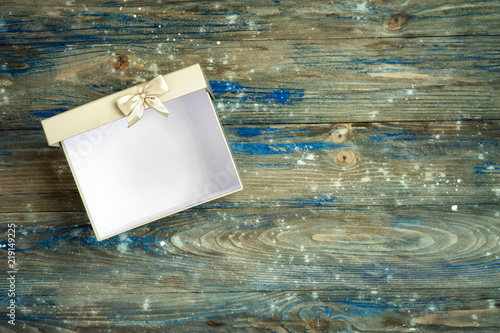 Open grey gift box on wooden background photo